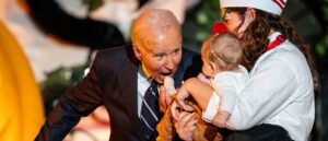 social-media-erupts-as-biden-bites-multiple-babies-dressed-in-costumes