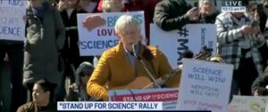 at-anti-trump-rally,-former-nih-director-sings-the-same-way-he-practices-science