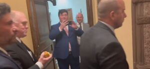 tom-homan-munches-on-apple,-smirks-as-he-faces-protesters-at-state-capitol
