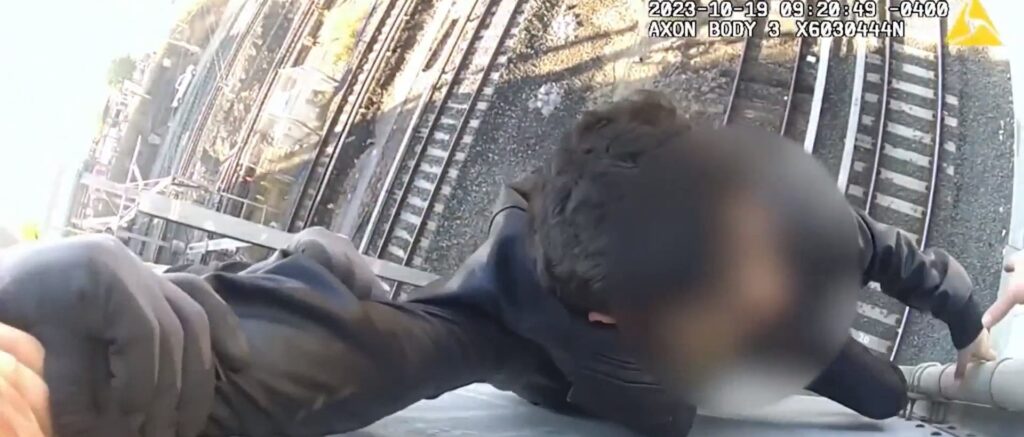 video-shows-police-rescuing-teen-hanging-off-bridge-as-train-approaches